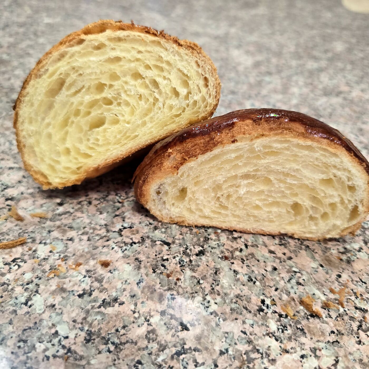 Miezul lamelar al unui croissant din unt 82%, tăiat pe jumătate