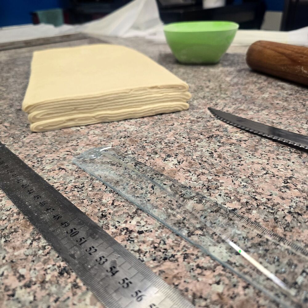 Foi de aluat laminate cu unt, pe masa de granit din laborator